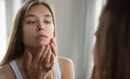 Moteris žiūri į save per veidrodį Moteris žiūri į save per veidrodį